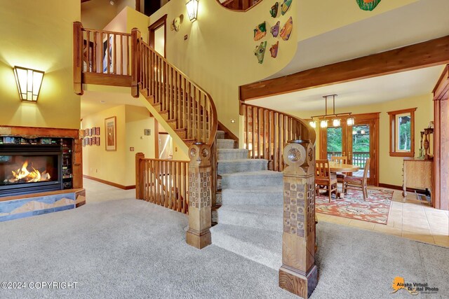 stairway with a high ceiling, beamed ceiling, tile patterned floors, and french doors