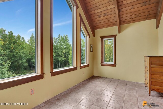 unfurnished sunroom featuring wooden ceiling and beam ceiling