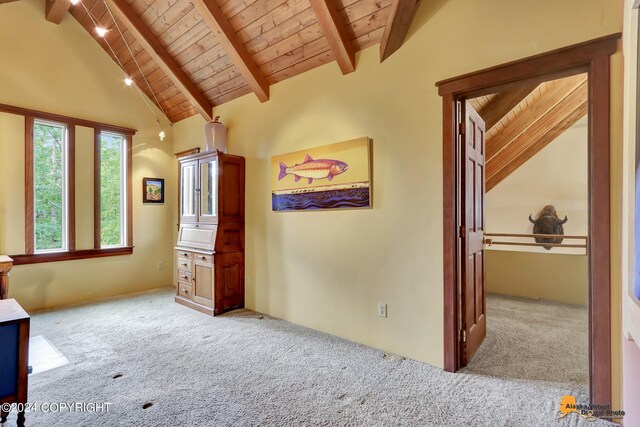 interior space with wooden ceiling, light colored carpet, beam ceiling, and high vaulted ceiling