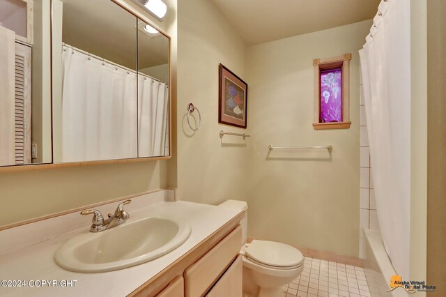 bathroom featuring vanity, tile patterned flooring, and toilet