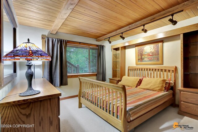 bedroom with wood ceiling, track lighting, carpet, and beam ceiling