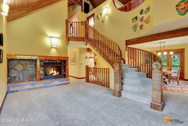 living room with a stone fireplace, beam ceiling, high vaulted ceiling, and carpet