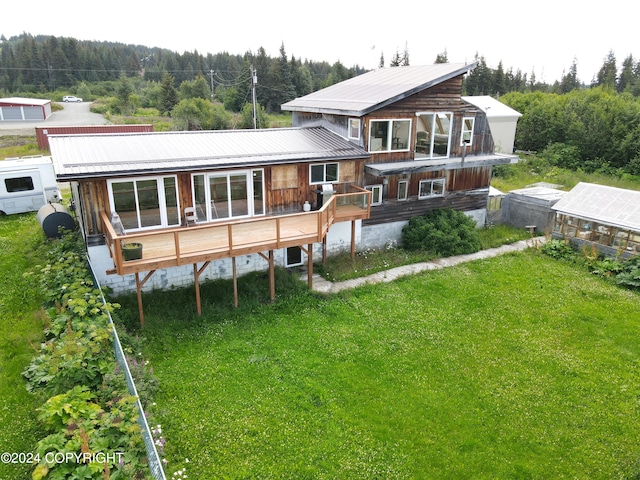 rear view of property featuring a deck and a yard