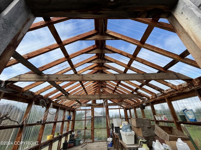 unfurnished sunroom featuring lofted ceiling with beams