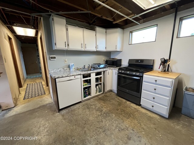 kitchen with concrete floors, white cabinetry, dishwasher, gas stove, and sink