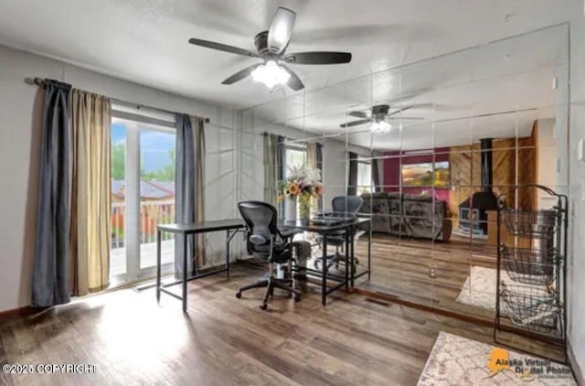 dining space with ceiling fan and wood-type flooring