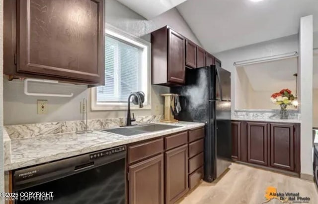 kitchen with dark brown cabinetry, black appliances, lofted ceiling, sink, and light wood-type flooring