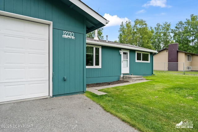 12230 Rainbow Ave, Anchorage, AK 99516 - doorway to property with a lawn and an attached garage