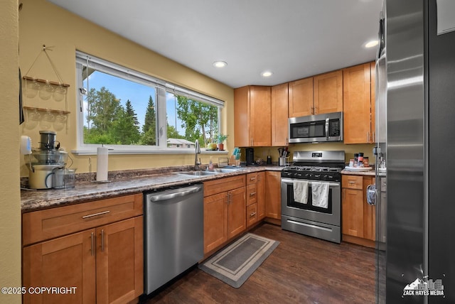 12230 Rainbow Ave, Anchorage, AK 99516 - kitchen featuring stainless steel appliances, dark wood-style floors, recessed lighting, brown cabinetry, and dark stone counters