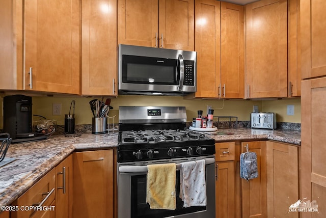 12230 Rainbow Ave, Anchorage, AK 99516 - kitchen with stainless steel appliances, light stone countertops, and brown cabinetry