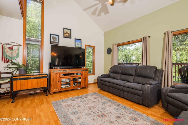 living area featuring light wood-type flooring, high vaulted ceiling, and a wealth of natural light