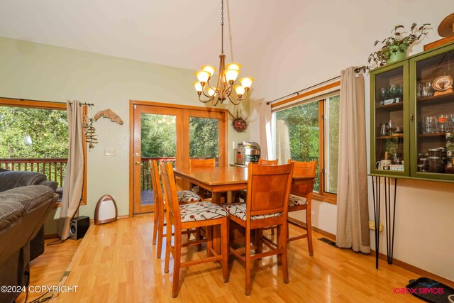 dining room with plenty of natural light, a notable chandelier, and light wood-type flooring