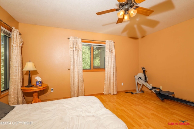 bedroom featuring ceiling fan, wood finished floors, and baseboards