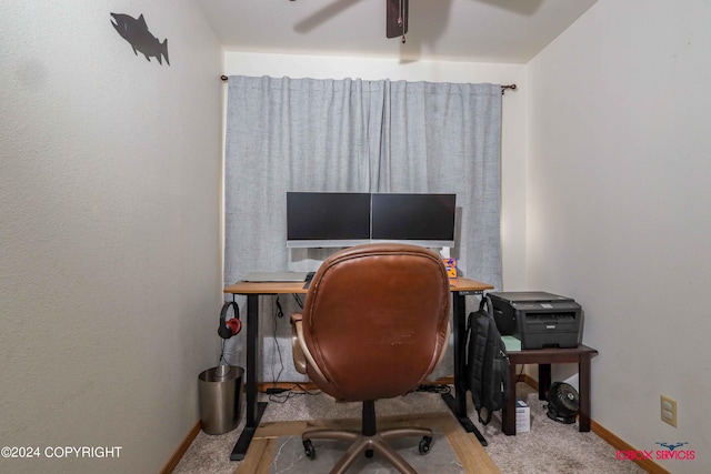 carpeted office space featuring ceiling fan and baseboards