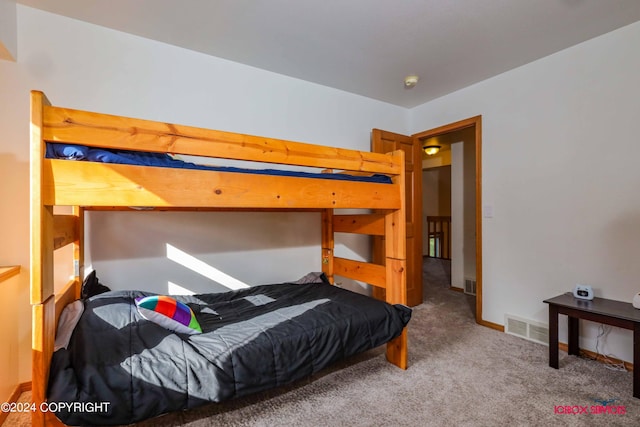 bedroom with carpet, visible vents, and baseboards