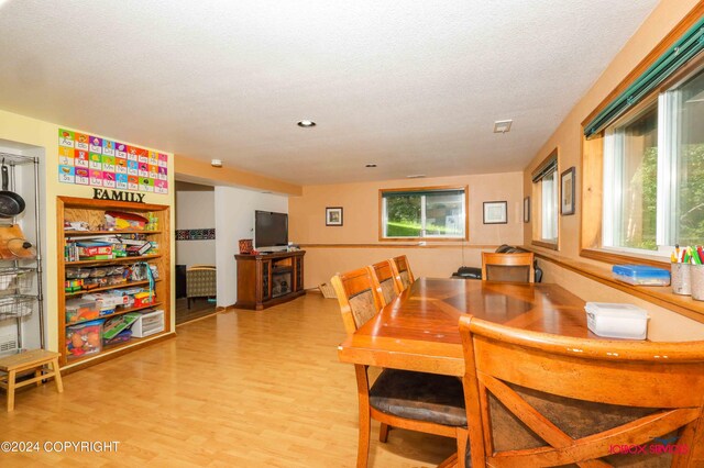 dining space featuring a textured ceiling and light hardwood / wood-style flooring