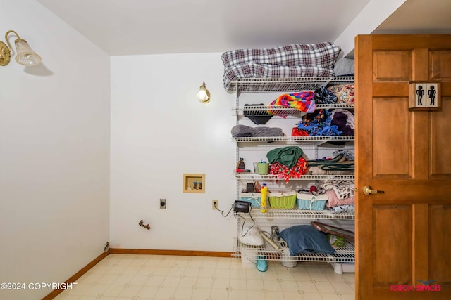 laundry area with laundry area, baseboards, hookup for a washing machine, hookup for an electric dryer, and light floors