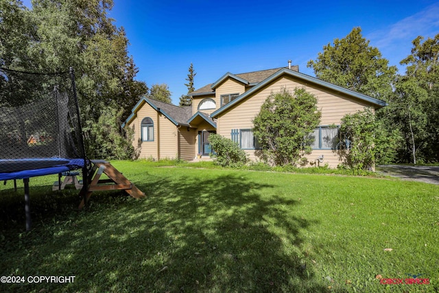 view of front of house with a trampoline and a front yard