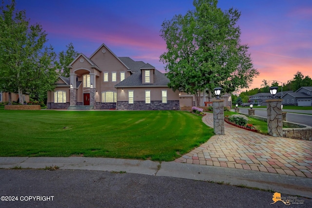 view of front of property with stone siding and a lawn