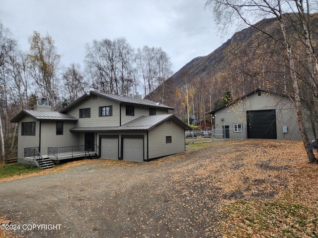 view of property exterior featuring a garage and a deck with mountain view