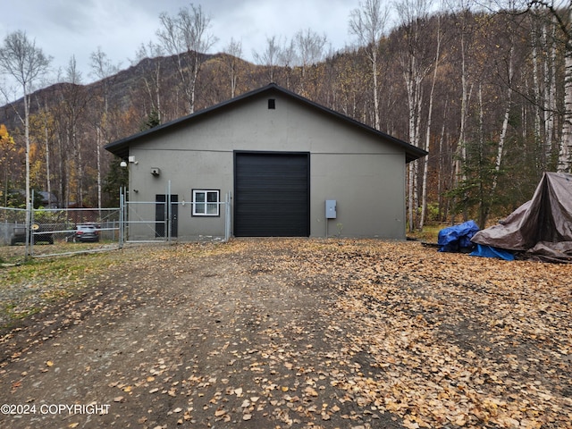 view of property exterior featuring a mountain view, an outbuilding, and a garage