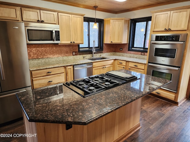 kitchen featuring sink, dark hardwood / wood-style flooring, dark stone counters, a kitchen bar, and appliances with stainless steel finishes