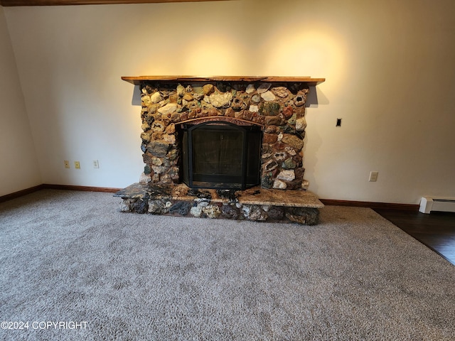 details featuring carpet floors, a stone fireplace, and baseboard heating