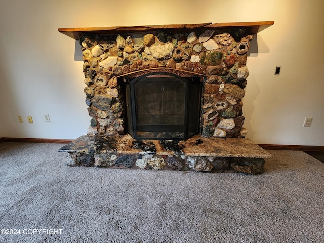 room details featuring carpet floors and a stone fireplace