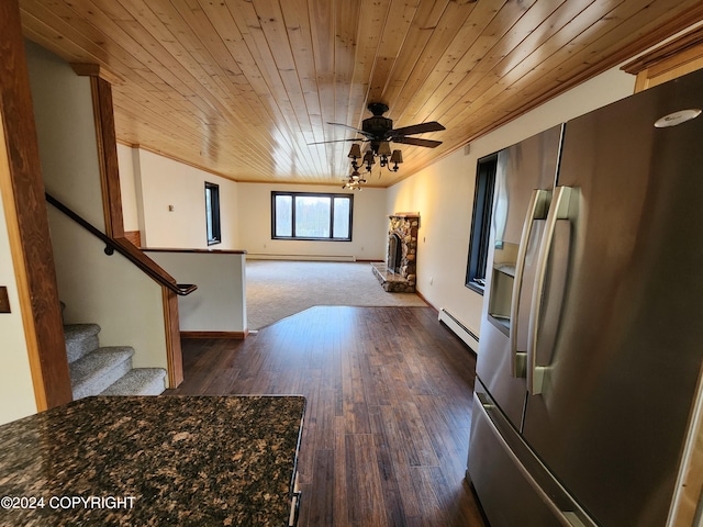 interior space with stainless steel fridge, ceiling fan, a baseboard heating unit, and wood ceiling