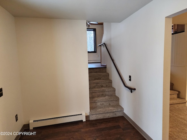 staircase with hardwood / wood-style floors and a baseboard radiator