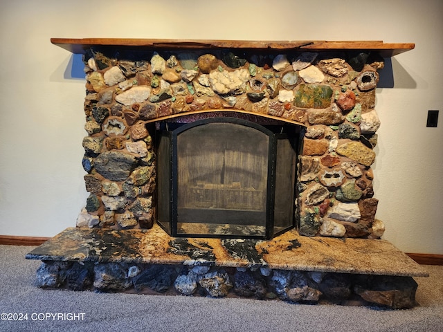 room details featuring a fireplace and carpet