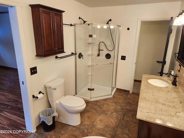 bathroom with tile patterned floors, a shower with door, vanity, and toilet