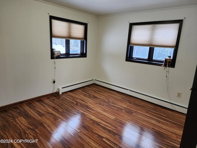 unfurnished room featuring hardwood / wood-style floors, crown molding, and a baseboard heating unit