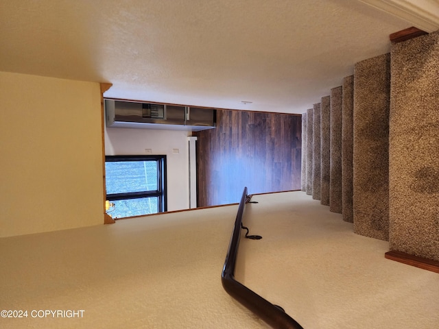 stairs featuring carpet floors, a textured ceiling, and wooden walls