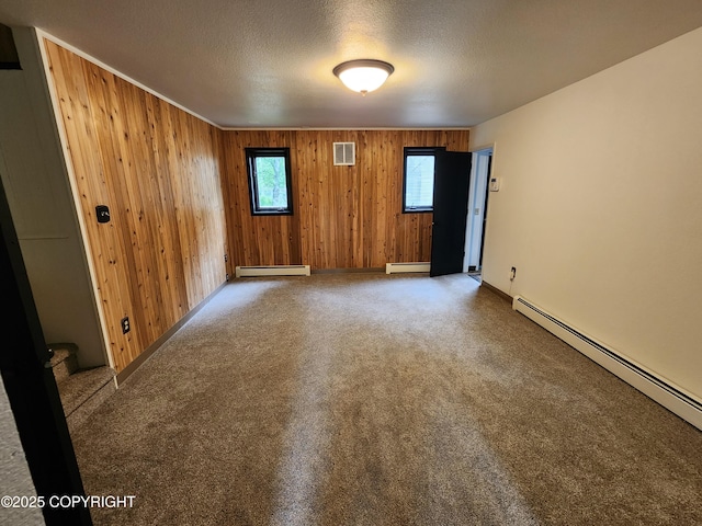 20527 Mark Cir, Chugiak, AK 99567 - spare room with baseboard heating, wood walls, a textured ceiling, and carpet flooring