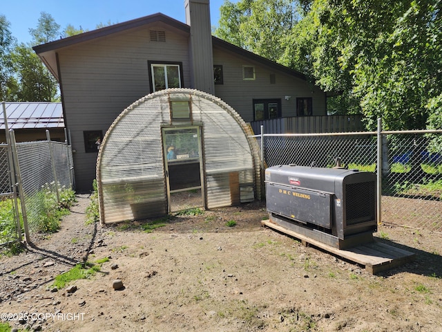 20527 Mark Cir, Chugiak, AK 99567 - back of property featuring a greenhouse, a chimney, and an outbuilding
