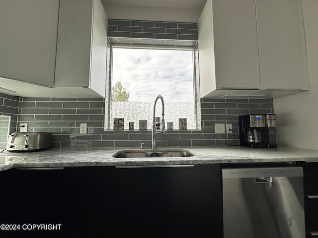 kitchen with decorative backsplash, sink, white cabinets, and stainless steel dishwasher