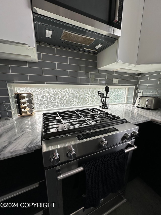 kitchen featuring white cabinets, appliances with stainless steel finishes, and backsplash