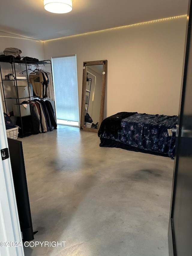 bedroom featuring concrete flooring