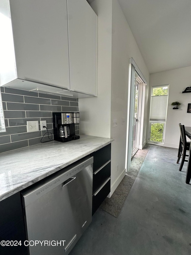 kitchen featuring tasteful backsplash, white cabinetry, stainless steel dishwasher, and light stone counters