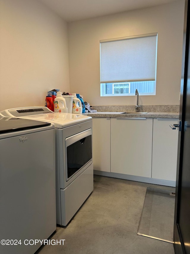 laundry area with cabinets, independent washer and dryer, and sink