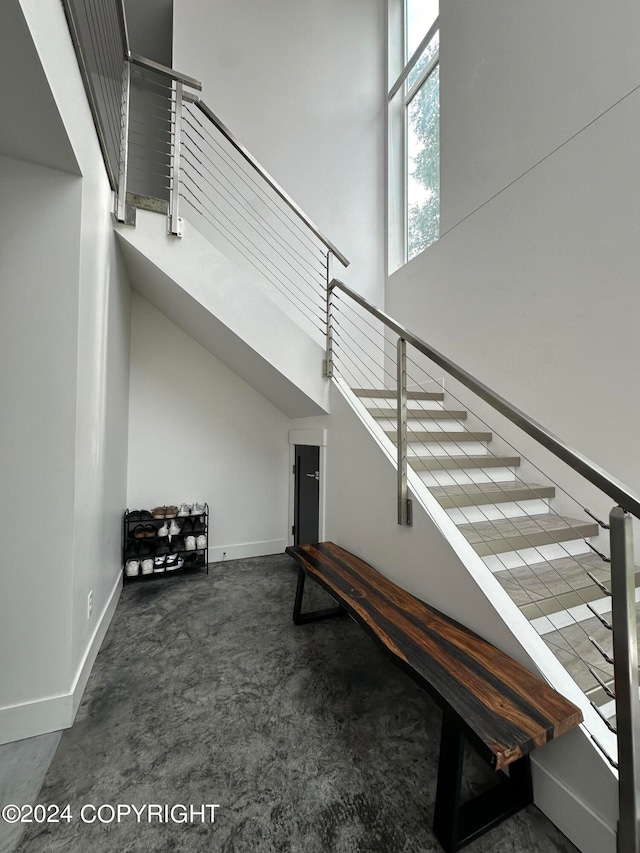 staircase featuring carpet flooring and a towering ceiling