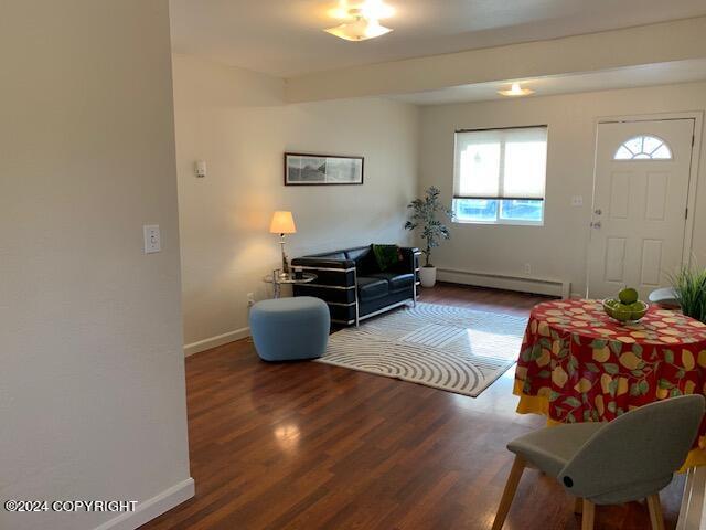 living room with a baseboard radiator, baseboards, and wood finished floors