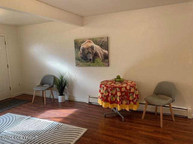 sitting room featuring beamed ceiling, baseboards, wood finished floors, and a baseboard radiator