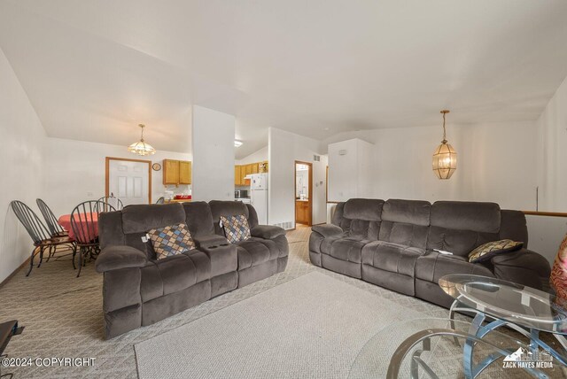 carpeted living room featuring lofted ceiling and a chandelier