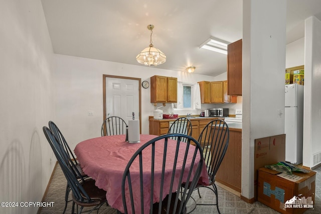 carpeted dining room with an inviting chandelier