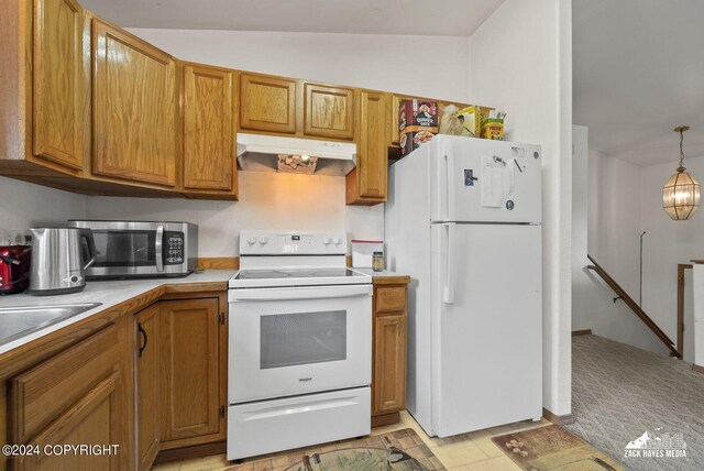 kitchen with vaulted ceiling, white appliances, and hanging light fixtures