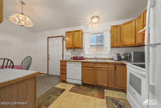 kitchen featuring white appliances, a chandelier, decorative light fixtures, and sink