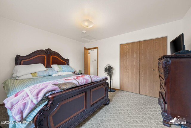 bedroom with light colored carpet and a closet