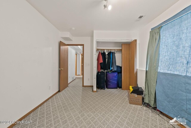 bedroom featuring light colored carpet and a closet